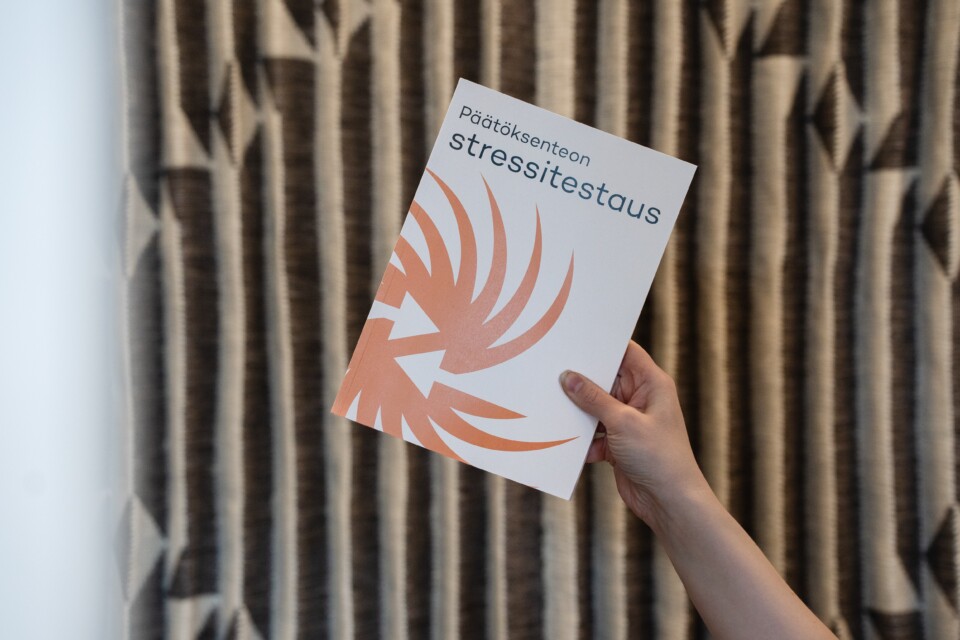 Kädessä kirja, jonka kannessa lukee "Päätöksenteon stressitestaus".