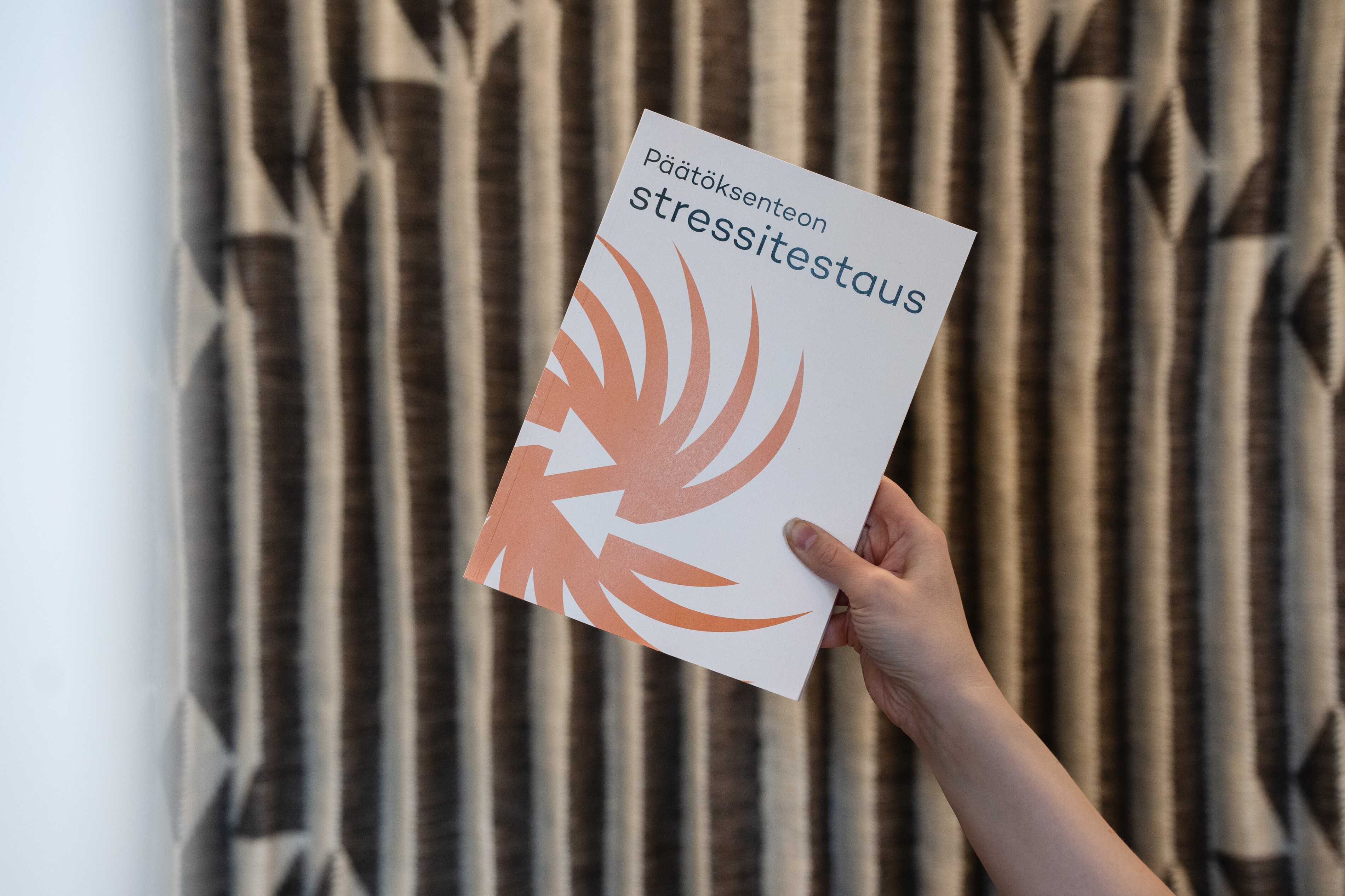 Kädessä kirja, jonka kannessa lukee "Päätöksenteon stressitestaus".